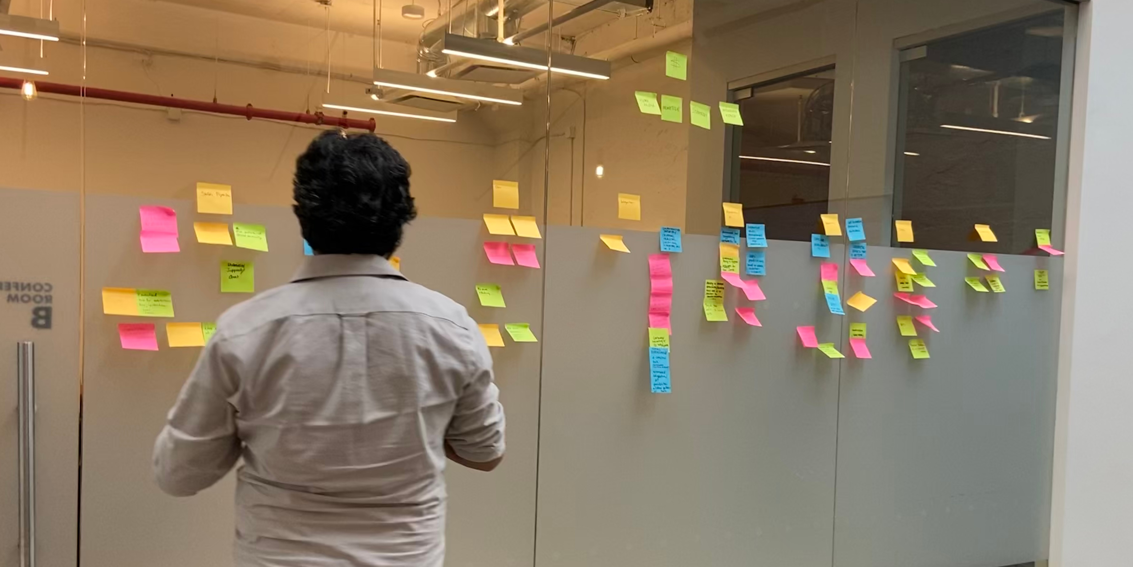 Colleague reviewing post-it notes after a brainstorming session.